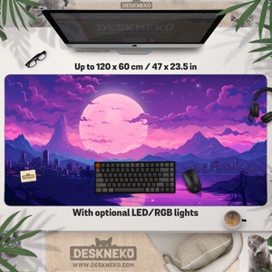 Puede incluir: Una alfombrilla de escritorio grande con un diseño de paisaje vibrante que presenta una luna rosa, montañas y un horizonte de la ciudad. La alfombrilla mide hasta 120 x 60 cm e incluye un teclado, un ratón y luces LED/RGB opcionales. La marca es Deskneko.