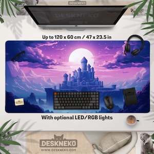 May include: A large rectangular desk mat featuring a fantasy castle design in purple and blue hues. The mat measures up to 120 x 60 cm and includes the text "DESKNEKO" and "With optional LED/RGB lights". A keyboard, mouse, and headphones are placed on the mat.