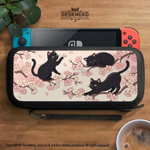 May include: Black Nintendo Switch case featuring a design of black cats on flowering branches. The case is black with a wrist strap. The text "DESKNEKO" is at the top. The Nintendo Switch is visible inside the case.