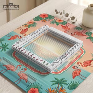 May include: A square mahjong mat featuring a tropical pattern of pink flamingos, green palm leaves, and hibiscus flowers. The mat has a central area with a sunset graphic and a rectangular arrangement of white mahjong tiles with black characters.