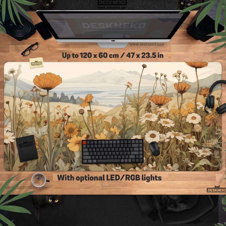 May include: A desk mat with a floral landscape design, featuring orange and white flowers and a mountain backdrop. The mat measures up to 120 x 60 cm and includes the text "With optional LED/RGB lights". The mat is designed for a desk.