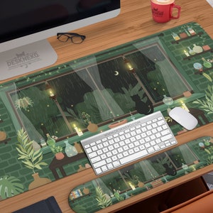 Può includere: Tappetino da scrivania verde con un'illustrazione stravagante di una scena di finestra piovosa e una silhouette di gatto nero. Il tappetino include un poggiapolsi per tastiera. Tastiera, mouse e tazza rossa sulla scrivania di legno.