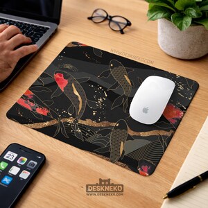 May include: Rectangular black mousepad with a koi carp design, gold detailing, and red accents. The mousepad sits on a wooden desk. The website address www.deskneko.com is printed on the mousepad.