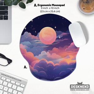 May include: Ergonomic mousepad with a dreamy night sky design, featuring a large pink moon, clouds, and stars. The mousepad is 9 inches by 10 inches. A white mouse rests on the pad. The website address is visible.