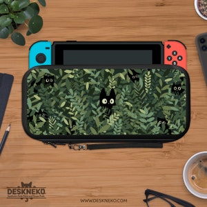 May include: A black Nintendo Switch case featuring a pattern of green leaves and black cats with white eyes. The case is open, revealing the Switch console with blue and red controllers. The case has a black zipper and a wrist strap. The Deskneko logo and website are visible.