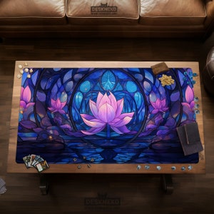 May include: A gaming mat featuring a stained-glass style design with a large pink lotus flower in the center, surrounded by blue and purple hues. The mat is rectangular and has the text "DESKNEKO" at the top and bottom.