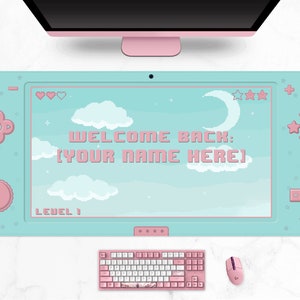 K&ouml;nnte beinhalten: Hellblaues Gaming-Mauspad mit Pixel-Design, mit dem Text "WELCOME BACK: [YOUR NAME HERE]" und einer Himmelszene mit Wolken und Mond. Enth&auml;lt eine rosa Tastatur, Maus und ein Headset.