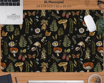 Może przedstawiać: Podkładka pod mysz XL z czarnym botanicznym wzorem z grzybami, paprociami, motylami i jagodami. Podkładka mierzy 65 x 35 cm. Adres strony internetowej www.deskneko.com jest widoczny na dole.