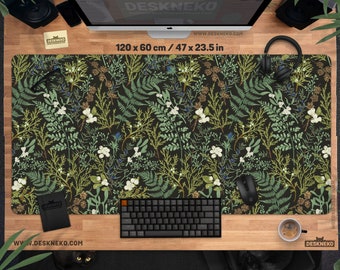 May include: A desk mat with a botanical design, featuring a pattern of green, white, and brown plants on a black backdrop. The mat measures 120 x 60 cm and has a keyboard, mouse, and coffee cup on it.