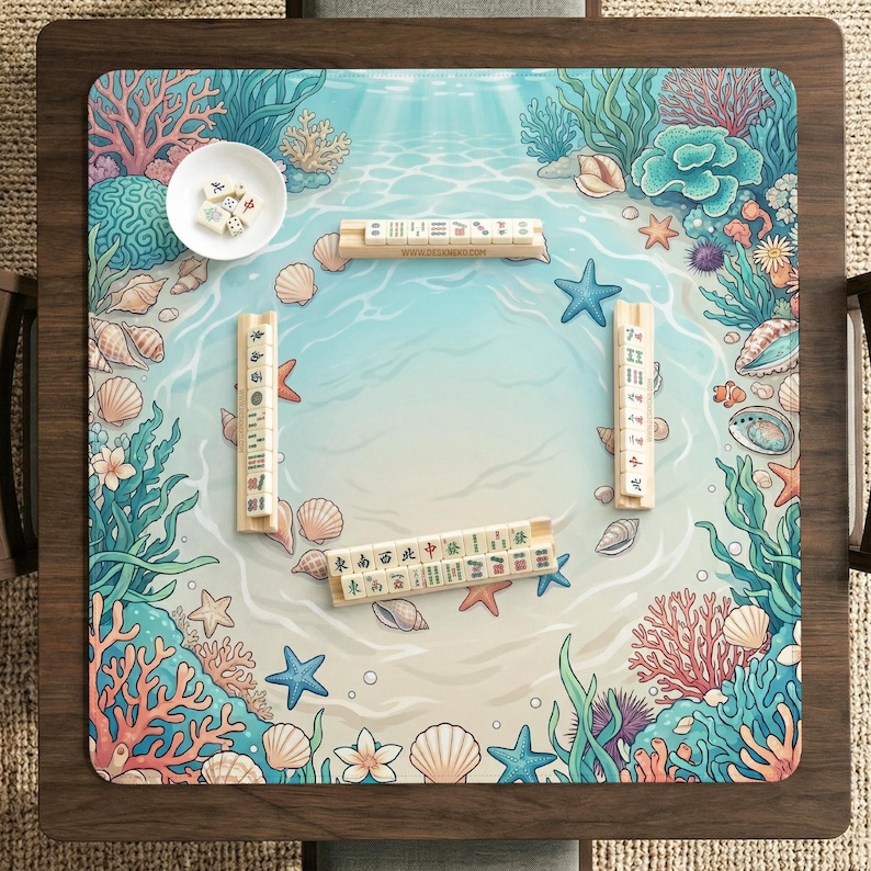 May include: Mahjong game set with a marine-themed play surface. The surface features an ocean design with coral, starfish, and seashells. The wooden tiles are arranged on the board, ready for play.