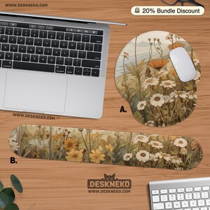 May include: A laptop, white mouse, and matching mousepad and wrist rest are displayed. The mousepad and wrist rest feature a floral design with white daisies and yellow flowers. The website address is visible on the items.