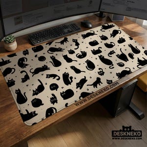 Puede incluir: Alfombrilla de escritorio rectangular beige con un patrón repetido de siluetas de gatos negros en varias poses. La alfombrilla incluye huellas de patas y el texto "WWW.DESKNEKO.COM".