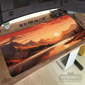 Puede incluir: Alfombrilla de escritorio rectangular con un diseño de paisaje de puesta de sol, con montañas y un lago. La alfombrilla mide hasta 120 cm de largo y 60 cm de ancho, con el texto "Up to 120 cm / 47" y "60cm / 23.5" impreso. La dirección del sitio web www.deskneko.com está impresa en la alfombrilla.