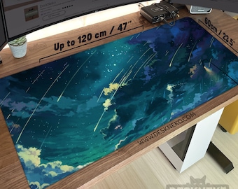 May include: A large rectangular desk mat with a celestial design. The mat features a dark blue and teal sky with white clouds and shooting stars. The mat is 47 inches long and 23.5 inches wide, with the text "Up to 120 cm / 47" and "60cm / 23.5" printed on it.