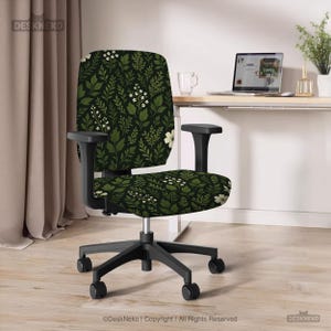 Könnte beinhalten: Ein Bürostuhl mit schwarzem Rahmen und Sitzfläche und Rückenlehne, die mit einem dunkelgrünen Blumenmuster mit weißen Blüten und grünen Blättern bedeckt sind. Der Stuhl hat schwarze Armlehnen und ein Fünf-Rollen-Gestell. Der Text "DeskNeko | Copyright | All Rights Reserved."