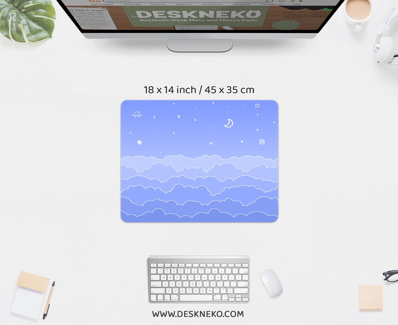 K&ouml;nnte beinhalten: Ein rechteckiges Mauspad mit hellblauem Himmelsdesign, mit wei&szlig;en Wolken, Sternen, einem Mond und einem kleinen Raumschiff. Das Mauspad misst 45 x 35 cm. Die Website-Adresse www.deskneko.com ist unten aufgedruckt.