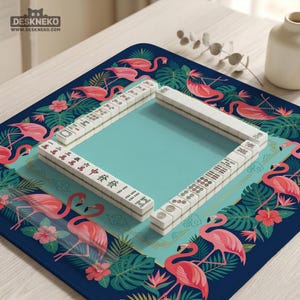 May include: A Mahjong game set with white tiles arranged on a teal playing surface. The mat features a blue border with pink flamingos, tropical leaves, and flowers. The top left corner has the text "DESKNEKO" and "www.deskneko.com".