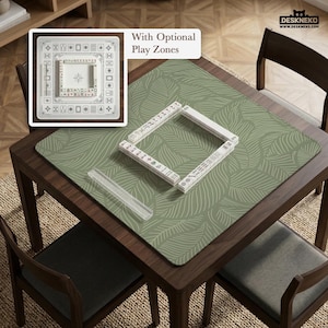 May include: A wooden mahjong table with a green leaf-patterned mat. The table has a set of white mahjong tiles arranged on the mat. The image also shows a close-up of a mahjong tile set and the text "With Optional Play Zones".