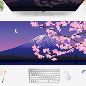 May include: A rectangular desk mat featuring a Japanese landscape design. The image depicts Mount Fuji with cherry blossoms, a crescent moon, and a gradient sky. The color palette includes shades of blue, purple, and pink.