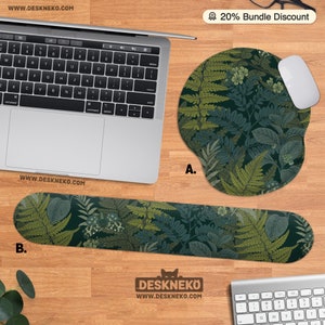 Pu&ograve; includere: Un'installazione informatica con un laptop, un mouse bianco e un tappetino per mouse e un poggiapolsi abbinati. Il tappetino per mouse e il poggiapolsi presentano un motivo botanico verde scuro con felci e altre foglie. Il testo "20% Bundle Discount" &egrave; visibile.