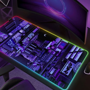 May include: A rectangular gaming mouse pad with a pixelated Tokyo cityscape design in shades of purple and blue. The pad has a glowing, multi-colored LED edge. The word "TOKYO" is visible on the pad.