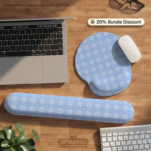 Puede incluir: Un conjunto de reposamuñecas y alfombrilla de ratón ergonómicos azul claro con un estampado de cuadros de pequeños cuadrados y corazones blancos. También se ven un ratón blanco y un ordenador portátil. Se muestra el texto "20% Bundle Discount".