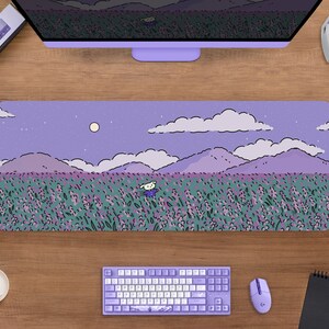 May include: A rectangular lavender mousepad featuring a whimsical illustration of a field of lavender flowers under a night sky with a full moon. A cartoon character is in the field. A keyboard, mouse, and headphones are visible.