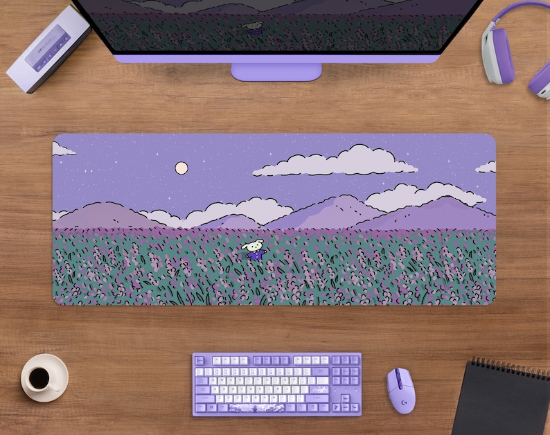 May include: A rectangular lavender mousepad featuring a whimsical illustration of a field of lavender flowers under a night sky with a full moon. A cartoon character is in the field. A keyboard, mouse, and headphones are visible.