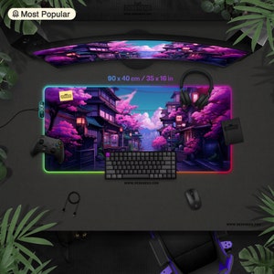 May include: A 90 x 40 cm gaming mouse pad with a Japanese street scene design. The pad features a vibrant illustration of a street scene with cherry blossom trees and buildings. A keyboard, mouse, and controller are also visible.
