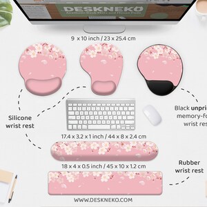 May include: A collection of desk accessories, including a silicone wrist rest, a black memory-foam wrist rest, and a rubber wrist rest. The items are pink with a white floral pattern. The dimensions are provided in inches and centimeters.