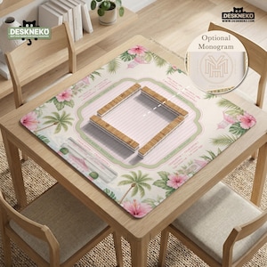 May include: A square mahjong mat featuring a light pink striped center, a green border, and a tropical pattern of pink hibiscus flowers and palm leaves. The mat includes printed game instructions and a central wooden tile rack arrangement.