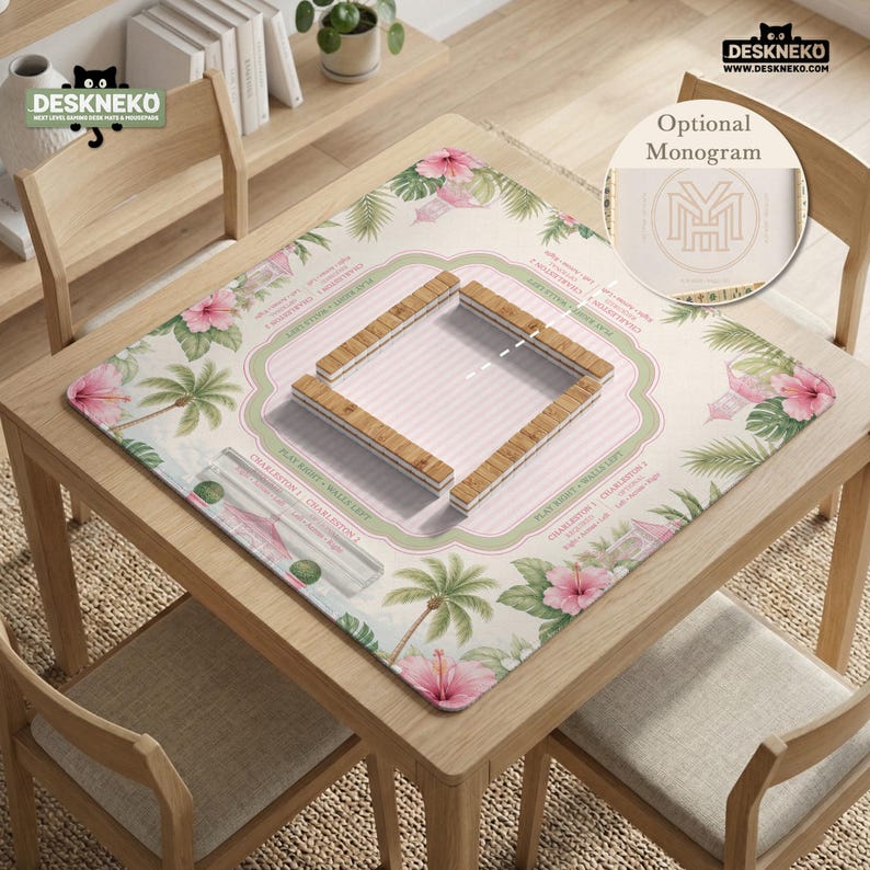 May include: A square mahjong mat featuring a light pink striped center, a green border, and a tropical pattern of pink hibiscus flowers and palm leaves. The mat includes printed game instructions and a central wooden tile rack arrangement.