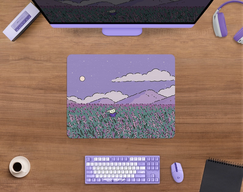 May include: A rectangular mousepad featuring a whimsical illustration of a character in a field of lavender flowers under a night sky with a full moon. The mousepad is surrounded by a computer monitor, keyboard, mouse, and headphones.