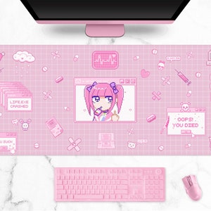 以下が含まれることがあります： ピンク色のデスクマット。格子模様に、女の子、ハート、コンピューターアイコンなどのピクセル化されたグラフィックが描かれています。マットには「LIFE.EXE CRASHED」、「OOPS! YOU DIED」、「YOU SUCK」の文字。ピンク色のキーボードとマウスが手前にあります。