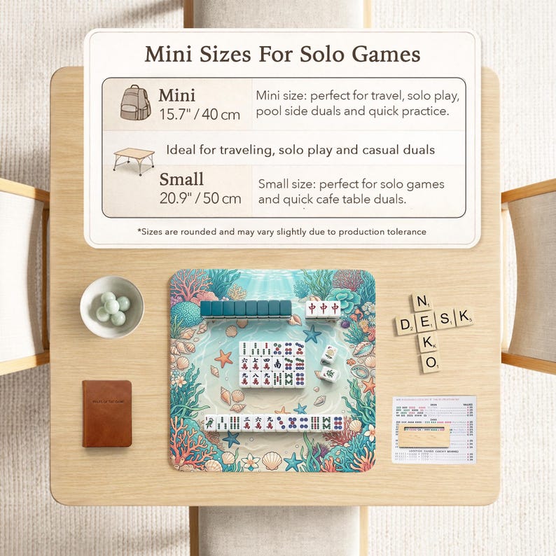 May include: A wooden table with a colorful game mat featuring a marine design, including coral and seashells. The table also has a small bowl with green spheres, a brown book, and tiles spelling "DESK". The text "Mini Sizes For Solo Games" is visible.