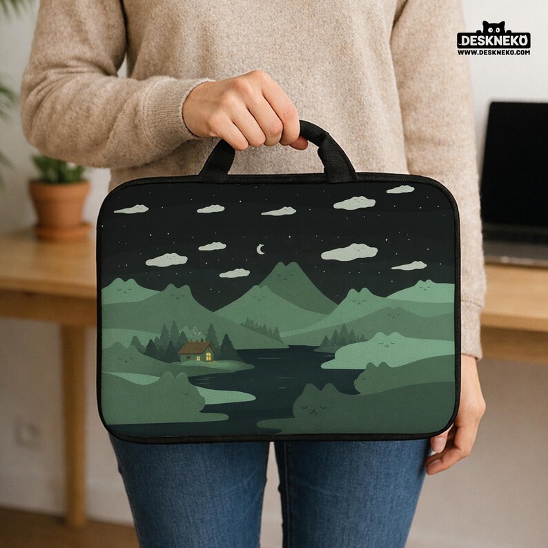 May include: A black laptop sleeve with a landscape design featuring mountains, a river, and a cabin under a starry night sky. The sleeve has a black handle and the text "DESKNEKO" and "WWW.DESKNEKO.COM".