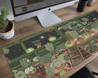 Könnte beinhalten: Ästhetische Schreibtischunterlage mit einer Illustration eines Gewächshauses voller Pflanzen und Cartoon-Frösche. Die Unterlage hat ein grünes und braunes Farbschema, mit dem Text "DeskNeko" und "Aesthetic Desk Mats and Mouse Pads" darauf gedruckt.