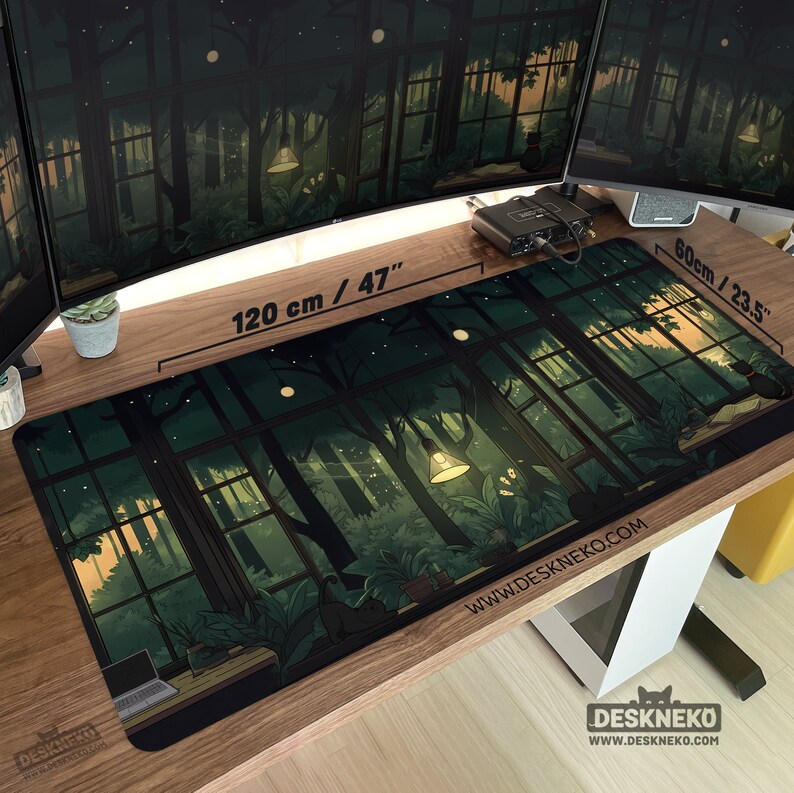 May include: A large, rectangular desk mat with a forest scene design. The mat is 47 inches long and 23.5 inches wide. The artwork features a window view of a forest with trees, plants, and a hanging lamp. The website address www.DESKNEKO.COM is printed on the mat.