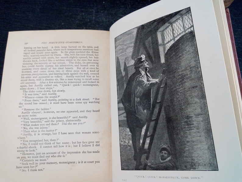Puede incluir: Un libro abierto con una ilustraci&oacute;n en blanco y negro de un hombre subiendo una escalera. La ilustraci&oacute;n est&aacute; junto al texto. El texto dice: "Quick! Quick! Monseigneur, Come Down."