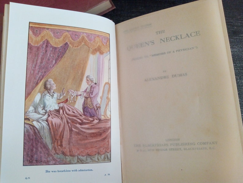 Puede incluir: Libro abierto con una ilustraci&oacute;n de "El collar de la reina" de Alexandre Dumas. La imagen muestra dos figuras, una en la cama y otra sosteniendo un collar. El t&iacute;tulo y el nombre del autor son visibles en la p&aacute;gina.