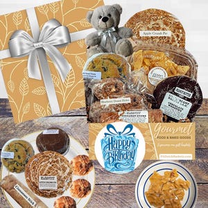 May include: A gift basket filled with gourmet food and baked goods, including a teddy bear, cinnamon sticks, apple crumb pie, chocolate whoopies, peanut butter, blueberry donut holes, and a happy birthday card. The basket is wrapped in a brown and white patterned paper with a silver bow.