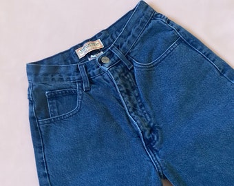 May include: A pair of blue denim jeans with a light wash. The jeans have a button fly and a small pocket on the right side.