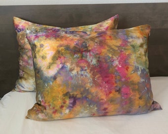 Puede incluir: Dos fundas de almohada decorativas con un patrón de teñido anudado en tonos de amarillo, rosa, morado y azul.