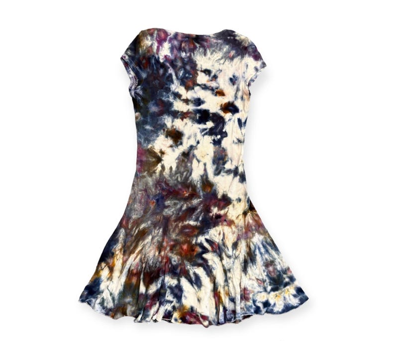 Pode incluir: Vestido tie-dye com decote redondo e mangas curtas. O vestido tem uma saia rodada. O tecido &eacute; estampado com cores branco, azul marinho, bord&ocirc; e roxo. &Eacute; uma pe&ccedil;a casual e feminina.
