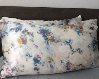 May include: Two white silk pillowcases with a tie-dye pattern in shades of blue, yellow, and pink.