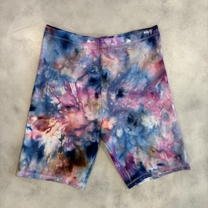 May include: Tie-dye biker shorts in shades of blue, purple, pink, and brown. The shorts have a stretchy, comfortable fit.
