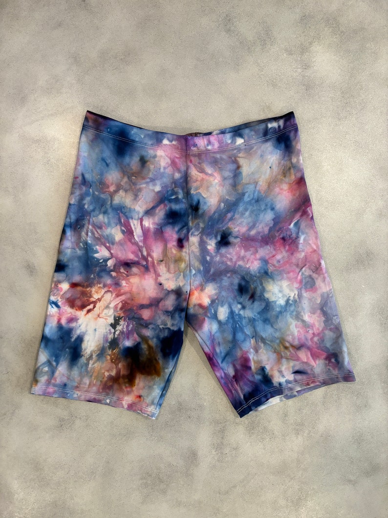 May include: Tie-dye biker shorts in shades of blue, purple, pink, and brown. The shorts have a stretchy, comfortable fit.
