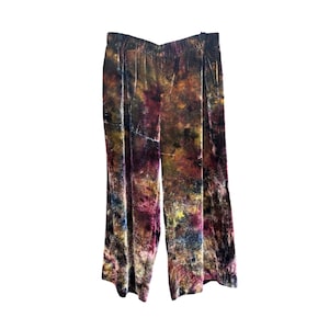 K&ouml;nnte beinhalten: Weite Hose mit abstraktem Batikmuster in Braun-, Gelb-, Lila- und Blaut&ouml;nen. Die Hose scheint aus einem weichen, samtartigen Material zu sein. Der Bund ist elastisch.