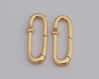 May include: Two gold-toned oval-shaped clasps with a small clear rhinestone in the center of each.