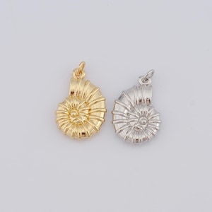 Pode incluir: Dois pingentes de concha de nautilus, um dourado e outro prateado, com um design em espiral detalhado.